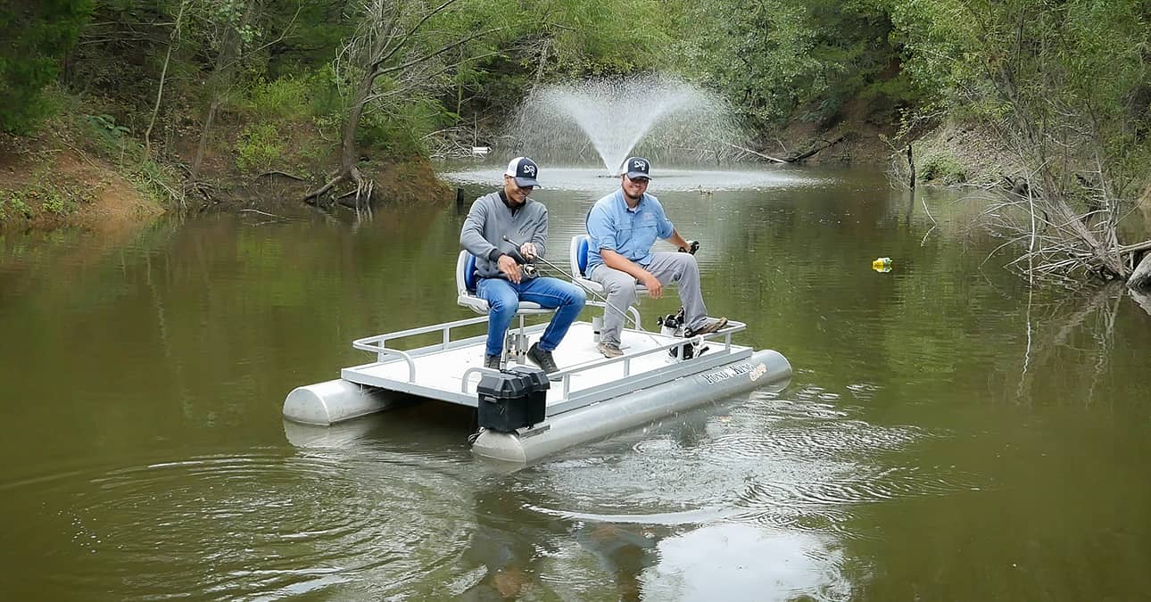 two men fishing with fountain in the background on two man champ