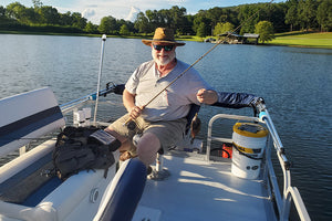 Smiling man fishing on pontoon boat