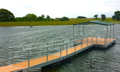floating dock with green awning and railing on both sides of walkway