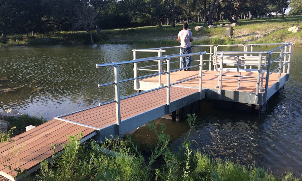 man fishing from a steel floating dock